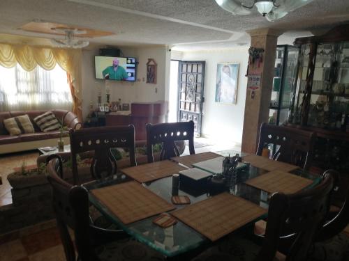 a dining room with a table and chairs and a couch at Hospedaje El Mirador in Iza