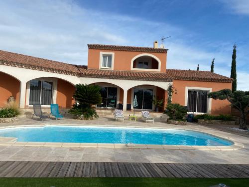 une villa avec piscine devant une maison dans l'établissement Villa en bordure de Garrigue, à Cabrières