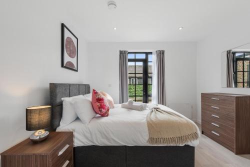 um quarto com uma cama, uma cómoda e uma janela em Lovely 1 Bedroom with outdoor space em Londres