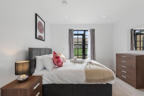 a bedroom with a bed and a dresser and a window at Lovely 1 Bedroom with outdoor space in London