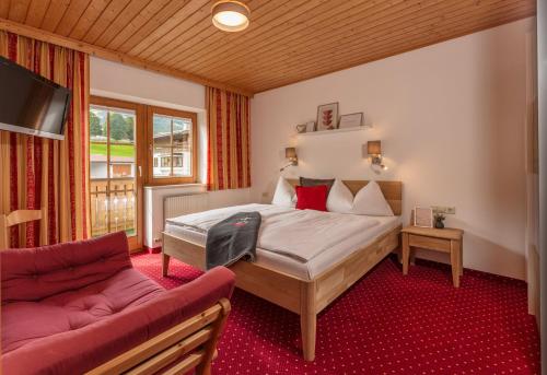 ein Schlafzimmer mit einem Bett und einem Sofa in der Unterkunft Haus Steirerland in Schladming