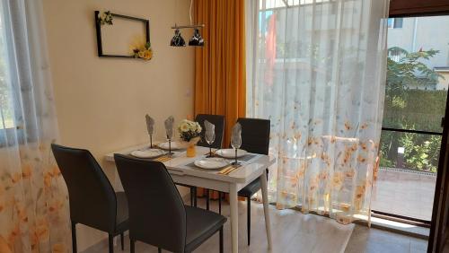 een eetkamer met een tafel en stoelen en een raam bij Sunrise City A2, Sarafovo in Boergas