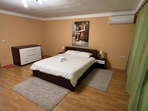 Cette chambre comprend un lit avec des draps blancs et une commode. dans l'établissement CASA DON, à Timişoara