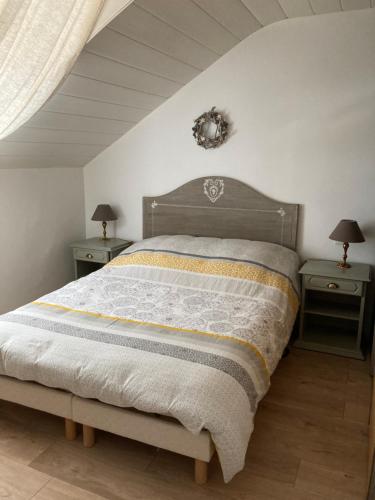 um quarto com uma cama grande e 2 mesas de cabeceira em Au passe temps em Beaucourt