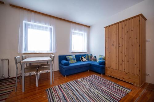 a living room with a blue couch and a table at Sonnenhaus in Gundersheim