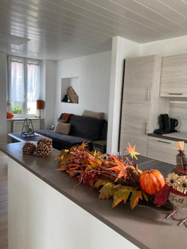 uma cozinha e sala de estar com um balcão com abóboras em Au passe temps em Beaucourt