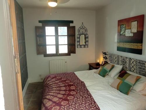- une chambre avec un grand lit et une fenêtre dans l'établissement Unique Village House, à Jimena de la Frontera