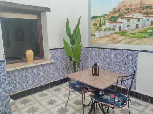 een tafel en stoelen in een kamer met blauwe tegels bij Unique Village House in Jimena de la Frontera