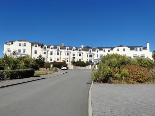 a street in front of a large white building at Tudor Apartment (Panoramic Sea Views) in Trearddur