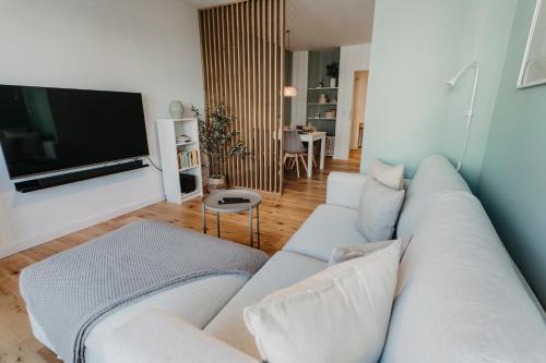 sala de estar con sofá blanco y TV de pantalla plana en Stylisches Apartment im Herzen Leipzigs mit Balkon en Leipzig