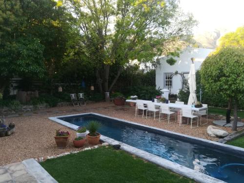 a backyard with a pool and a table and chairs at The Cottage on 55 in Franschhoek