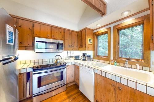 a kitchen with wooden cabinets and a sink and a refrigerator at The Pond House in Plymouth