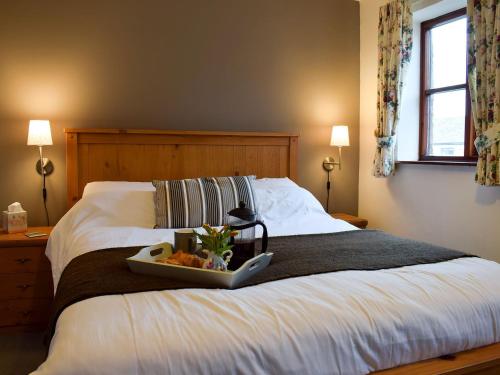 a bed with a tray of food on top of it at Moordale Cottage in Reeth