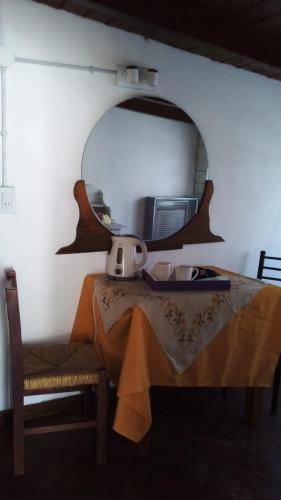 un espejo en una pared con una mesa y una silla en Victoria en Esquel