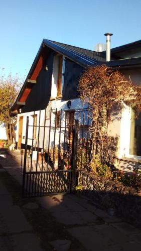 a house with a fence in front of it at Victoria in Esquel