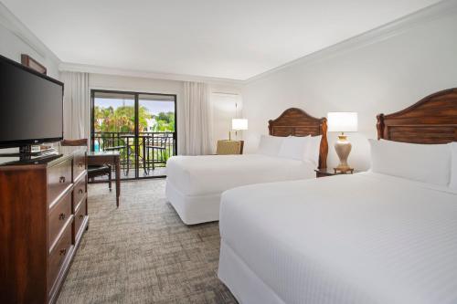 ein Hotelzimmer mit 2 Betten und einem Flachbild-TV in der Unterkunft Saddlebrook Golf Resort & Spa Tampa North-Wesley Chapel in Wesley Chapel