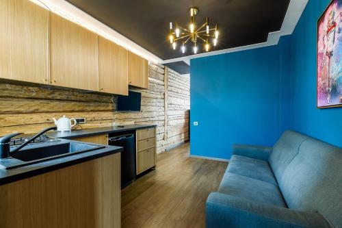 a kitchen with blue walls and a blue couch at Apartments in Kaunas in Kaunas