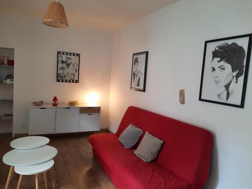 een woonkamer met een rode bank en een tafel bij BIANCU NERU in Châteauroux