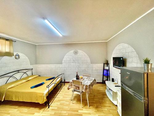 - une chambre avec un lit, une table et un réfrigérateur dans l'établissement Monolocale Deluxe a 2,7 km dal mare per 2 persone, à Siderno Marina