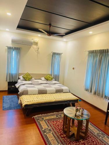 a bedroom with two beds and a table in it at Castle Villa in Ernakulam