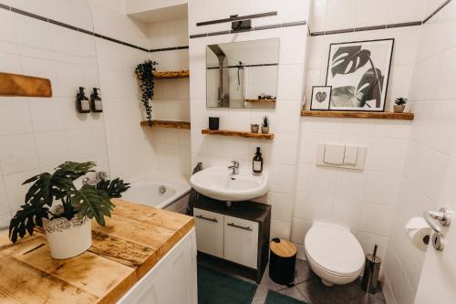 La salle de bains blanche est pourvue d'un lavabo et de toilettes. dans l'établissement Stilvolle, gemütliche Wohnung mitten im ZENTRUM, à Leipzig