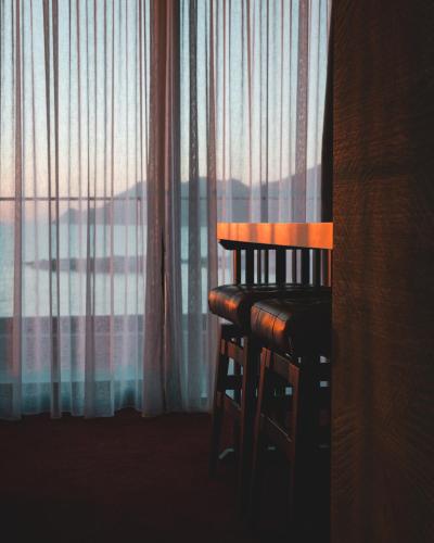 a wooden chair sitting in front of a window at Kalamper Hotel & Spa in Dobra Voda