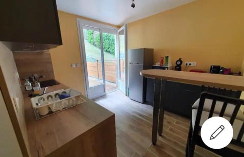 - une cuisine avec un comptoir et un réfrigérateur dans la chambre dans l'établissement Maison de Nicolas et Sonia, à Bort-les-Orgues