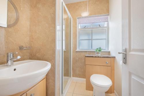 ein Badezimmer mit Waschbecken und Toilette und einem Fenster in der Unterkunft Cottage 9 Old Farmhouse Braithwaite in Keswick