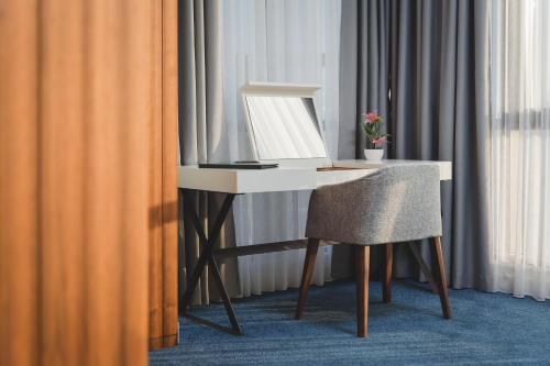 a white desk with a chair next to a window at Kalamper Hotel & Spa in Dobra Voda