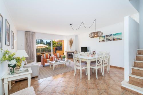 a dining room and living room with a table and chairs at Jardins Meia Praia 104 by Algarve Golden Properties in Lagos
