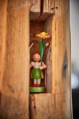 a toy figurine of a person holding a flower in a box at Ferienhaus Asten-Lodge in Winterberg