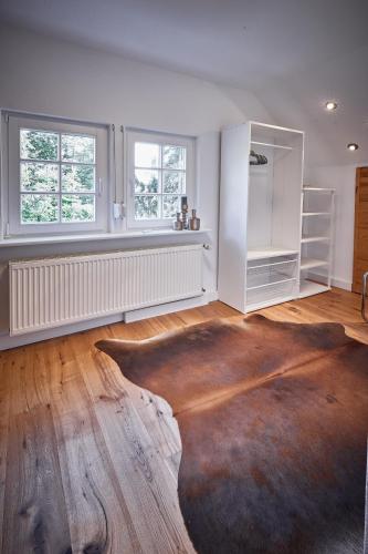 a living room with a wooden floor and two windows at Ferienhaus Asten-Lodge in Winterberg