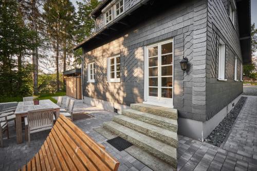 a brick house with a bench and a table at Ferienhaus Asten-Lodge in Winterberg