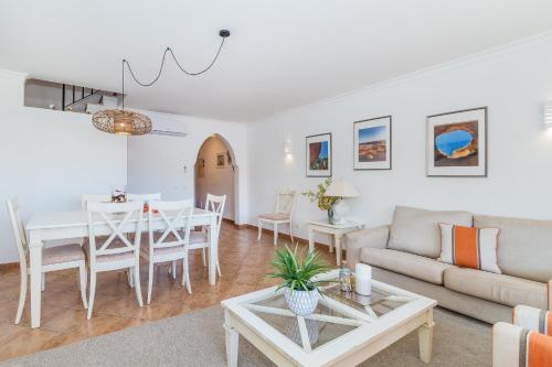 a living room with a table and a couch at Jardins Meia Praia 104 by Algarve Golden Properties in Lagos