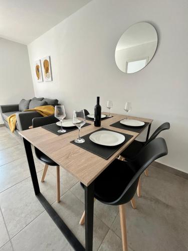 mesa de comedor con copas de vino y espejo en Hermoso Departamento Zona Residencial Mendoza, en Mendoza