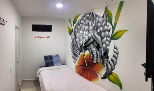 a bedroom with a flower mural on the wall at The Mural Hostel Bogotá in Bogotá