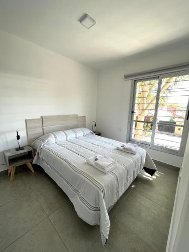 una camera bianca con un grande letto e una finestra di Hermoso Departamento Zona Residencial Mendoza a Mendoza