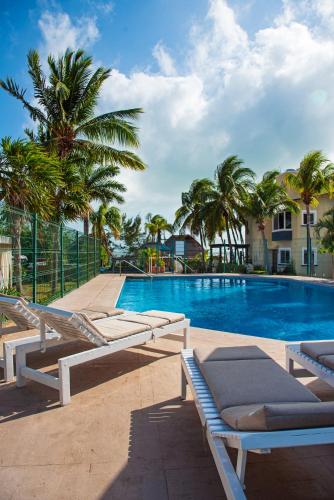 a swimming pool with lounge chairs and palm trees at Newly renovated ! Villa Laguna Cancun in Cancún