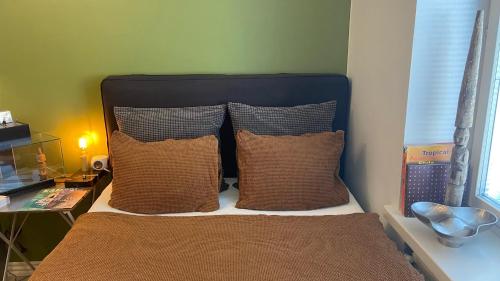 um quarto com uma cama com três almofadas em Absolute Center Helsinki Compact Apartment em Helsinque