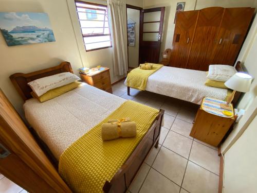 Hermanus的住宿－Hermanus 60 on Flat，一间卧室设有两张床和黄色毯子