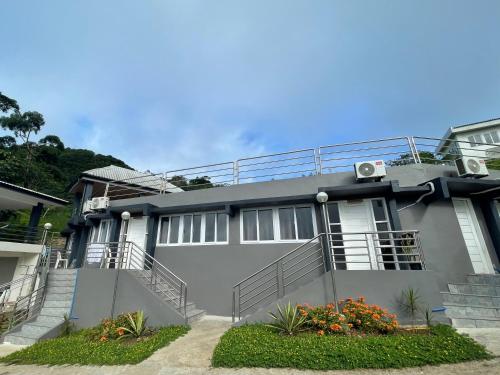 a gray house with stairs and flowers in front of it at La View Mountain Resort in Damasanan