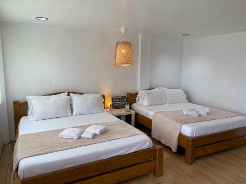 two beds in a room with towels on them at La View Mountain Resort in Damasanan