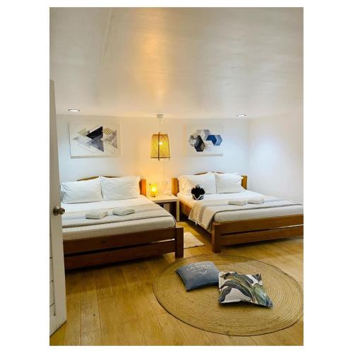 a bedroom with two beds and a table and a rug at La View Mountain Resort in Damasanan