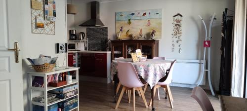 une cuisine avec une table et des chaises dans une pièce dans l'établissement BERCK Maison de vacances avec terrasse et jardin,, à Berck-sur-Mer