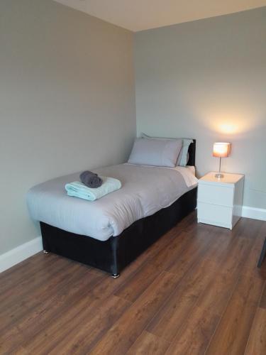 una camera con un letto e una lampada su un pavimento in legno di Hilltop Haven, Doolin a Doolin