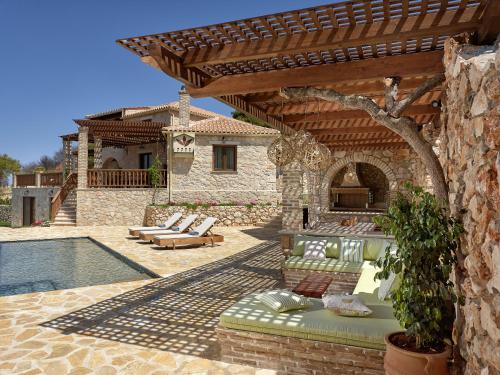 een patio met een zwembad en een huis bij Villa Meralia in Anafonítria
