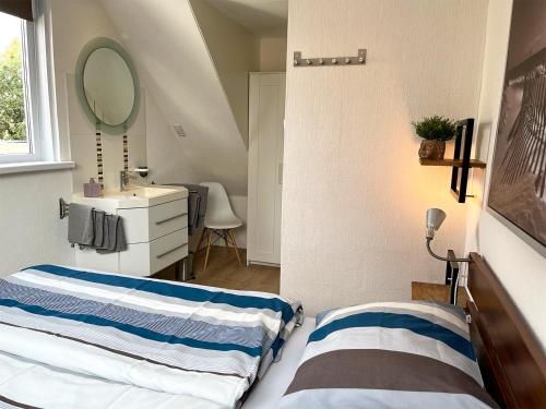 een kleine slaapkamer met 2 bedden en een spiegel bij Pollux bij Vuurtoren en strand in Noordwijk aan Zee