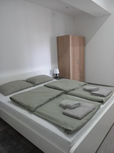 a large bed in a white room with avertisementatronatronstrationstration at Apartmani Dubrava 3 in Zagreb