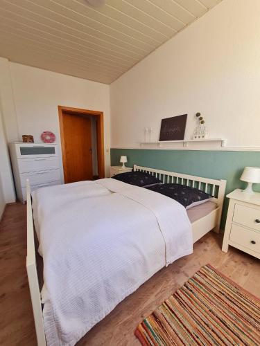 a bedroom with a large white bed and a rug at City-Wohnung Salzwedel in Salzwedel