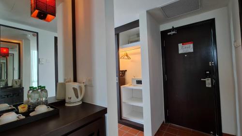 a bathroom with a black door and a mirror at Swan Garden Hotel in Melaka
